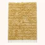 Cream Beni Ourain Yakout rug with textured horizontal stripes, flat lay on plain background