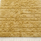 Close-up of cream Yakout rug showing textured horizontal stripes and wool pile depth
