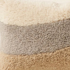 Side view of the Tilelli Moroccan pillow showing its cream, grey and sand wool pile