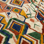 Pattern close-up of Asifran showing layered diamonds, zigzags and slim linear marks in cream and earthy colors