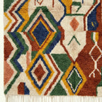 Fringe and edge detail of Asifran beside layered cream, forest green and terracotta geometric bands