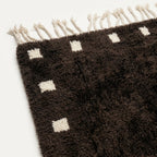 Close-up of the dark brown and ivory wool rug border.