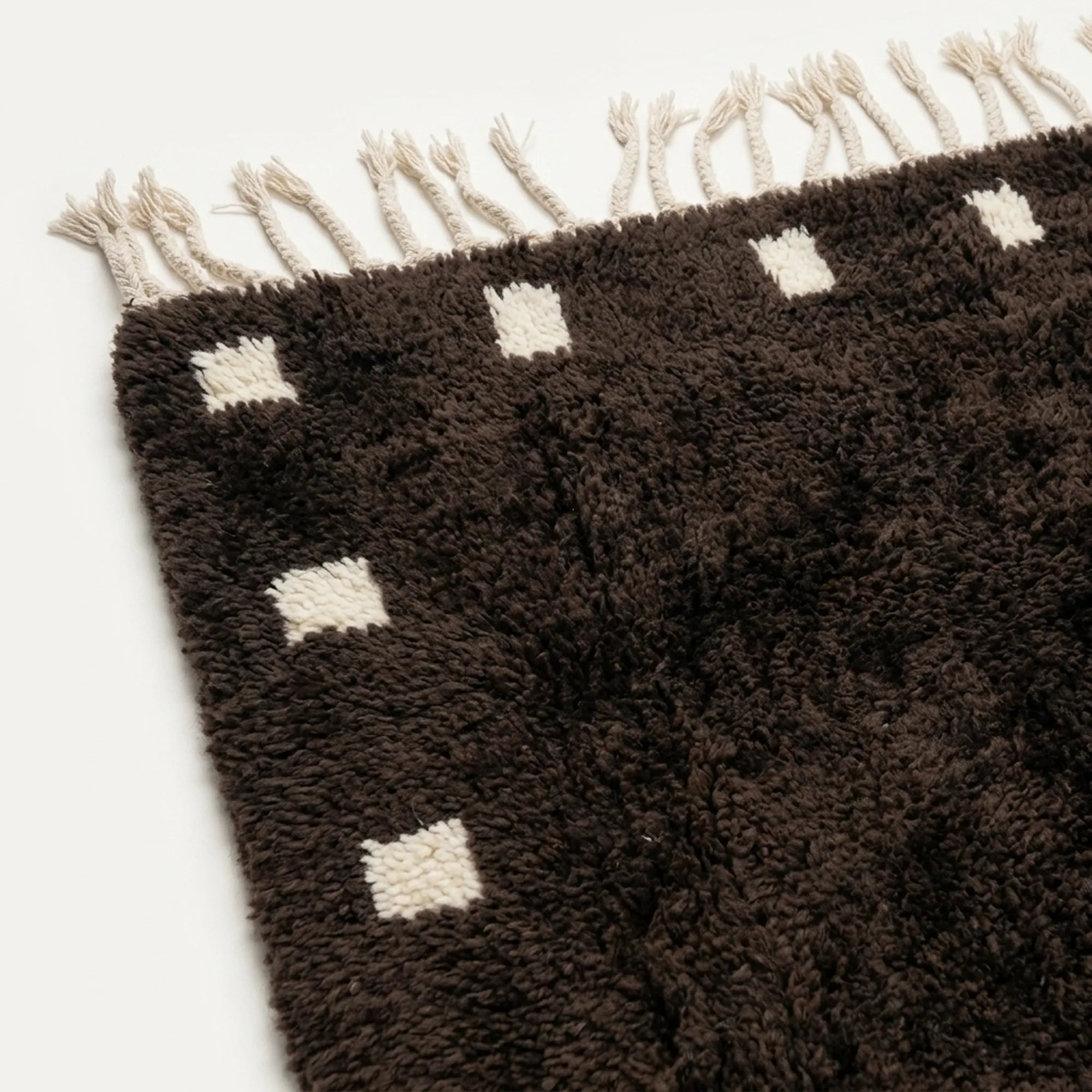 Close-up of the dark brown and ivory wool rug border.
