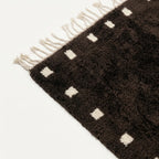 Fringe and border detail of the dark brown and ivory Moroccan wool rug.