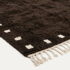 Natural wool pile detail on the dark brown and ivory square border rug.