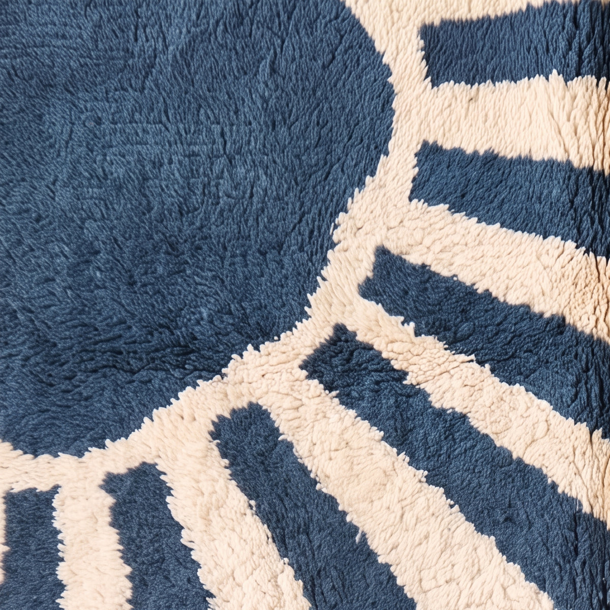 Close-up of thick soft wool pile showing contrast between denim bands and ivory background
