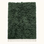 Forest green Beni Ourain rug Tafrara with textured pile and ivory fringe, flat lay on plain background