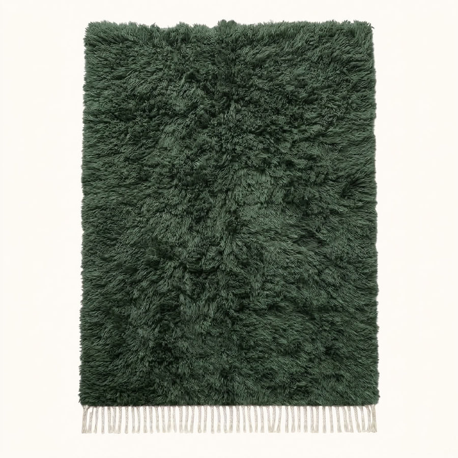Forest green Beni Ourain rug Tafrara with textured pile and ivory fringe, flat lay on plain background