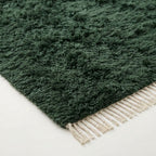 Angled view of thick pile and ivory fringe on forest green Beni Ourain rug Tafrara
