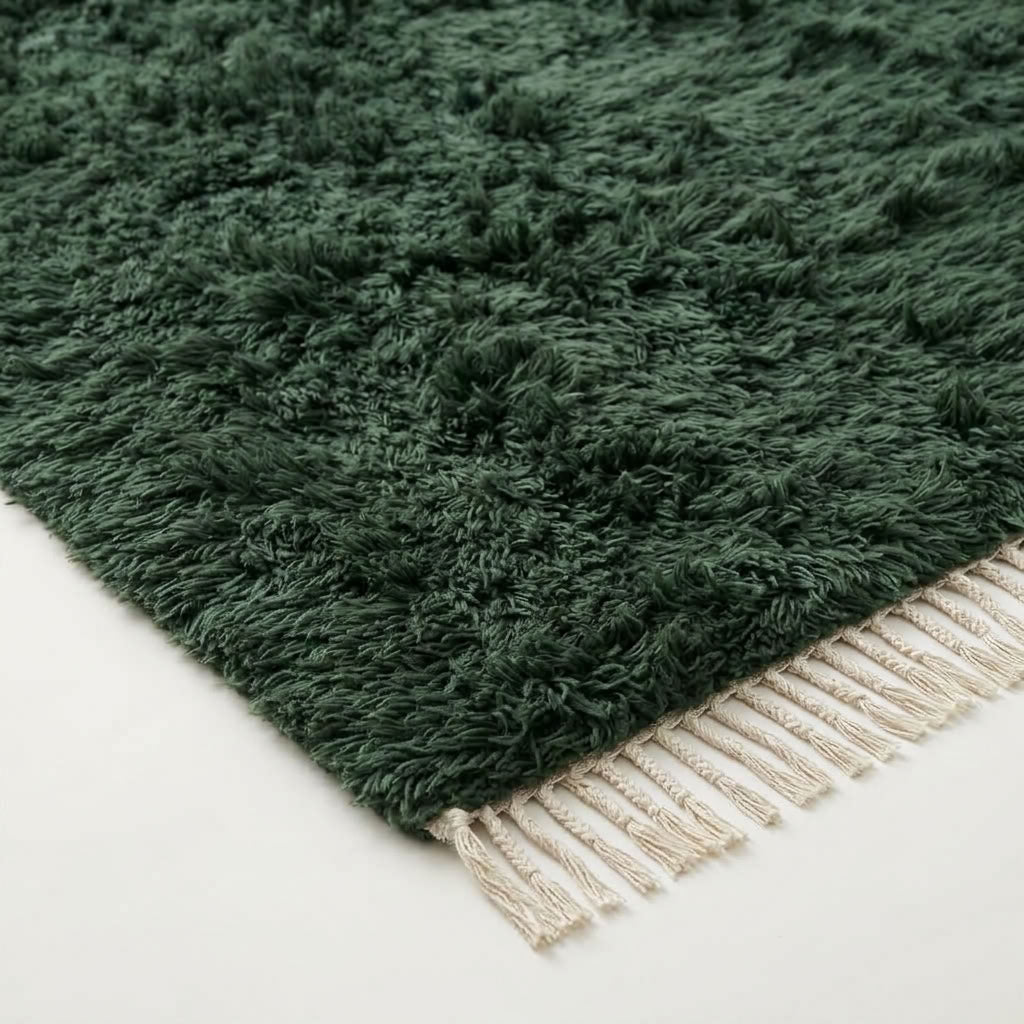 Angled view of thick pile and ivory fringe on forest green Beni Ourain rug Tafrara
