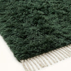 Close-up of forest green pile texture and ivory fringe on Beni Ourain rug Tafrara