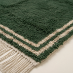 Detailed corner view of the Tafukt forest green and ivory Beni Ourain rug.