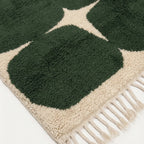 Close-up of the forest green rounded grid pattern on the Anir ivory wool rug.