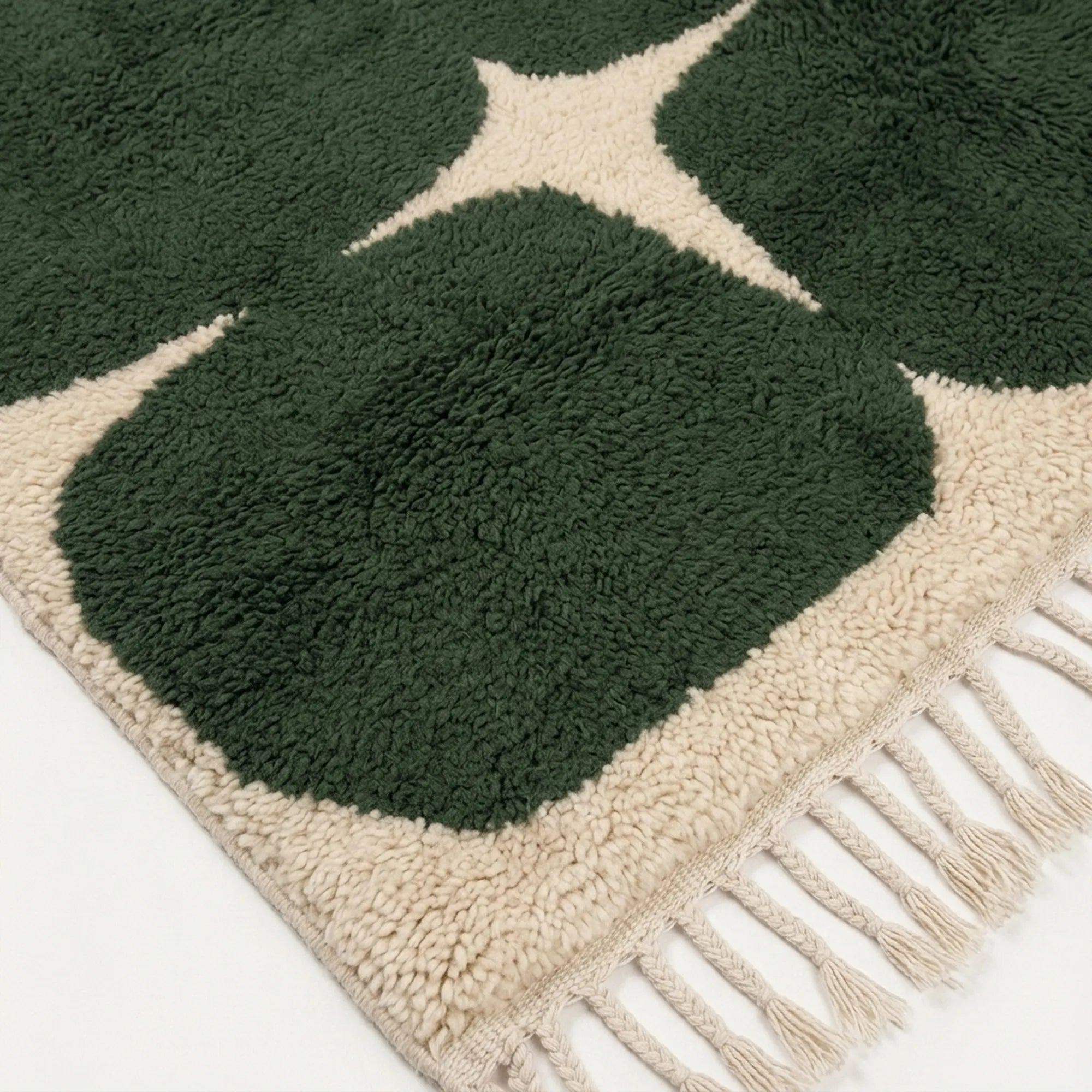 Close-up of the forest green rounded grid pattern on the Anir ivory wool rug.