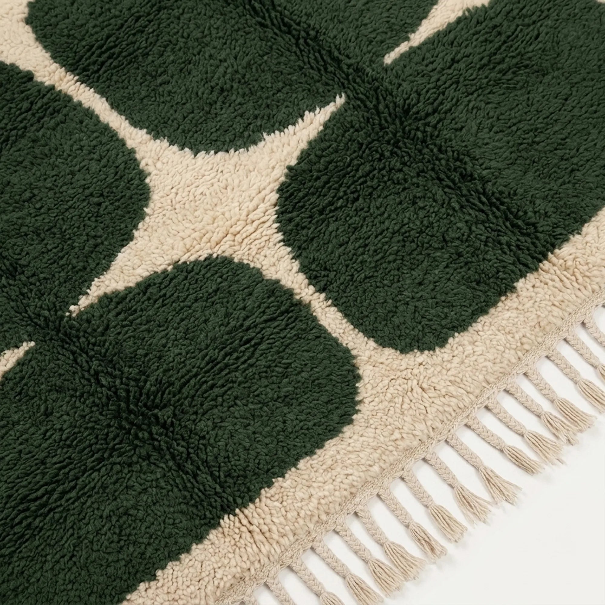 Close-up of the natural Atlas wool texture on the Anir forest green and ivory rug.
