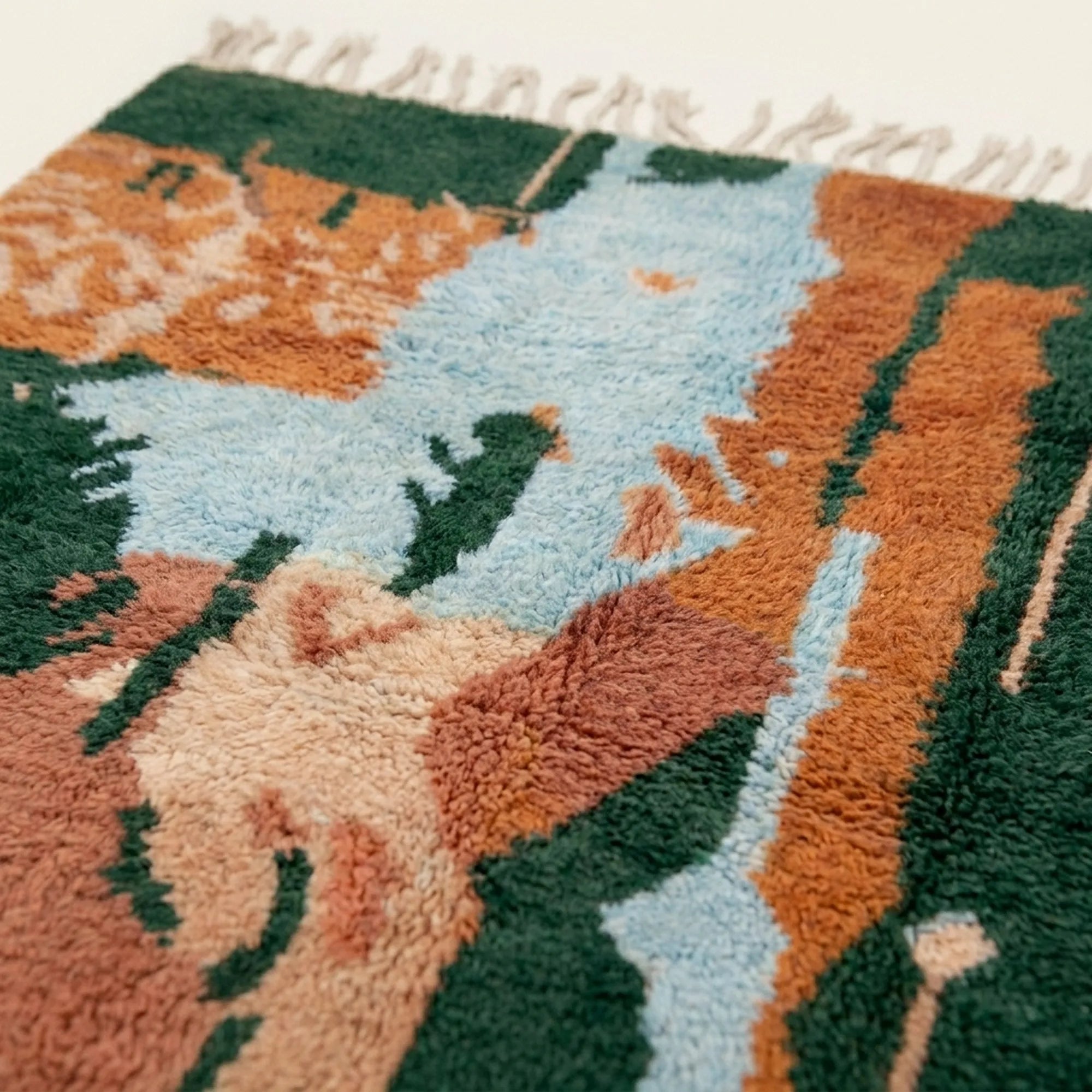 Pattern close-up of Azelwan showing forest green fields, terracotta bands, pale blue areas and abstract handwoven marks