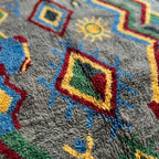 Close-up of a multicolor diamond motif on the Abridan Boujaad rug against its plush gray ground