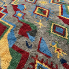 Angled wool-pile detail of Abridan showing gray plush texture with red, blue, green and ochre accents