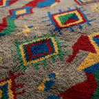 Detailed view of Abridan showing stepped zigzags, diamonds and small handwoven symbols on gray wool