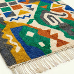 Fringe and lower-edge detail of the Awragh Boujaad rug with green, cobalt and mustard geometric motifs