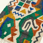 Angled wool-pile detail of the Awragh Boujaad rug showing multicolor hand-knotted geometric shapes