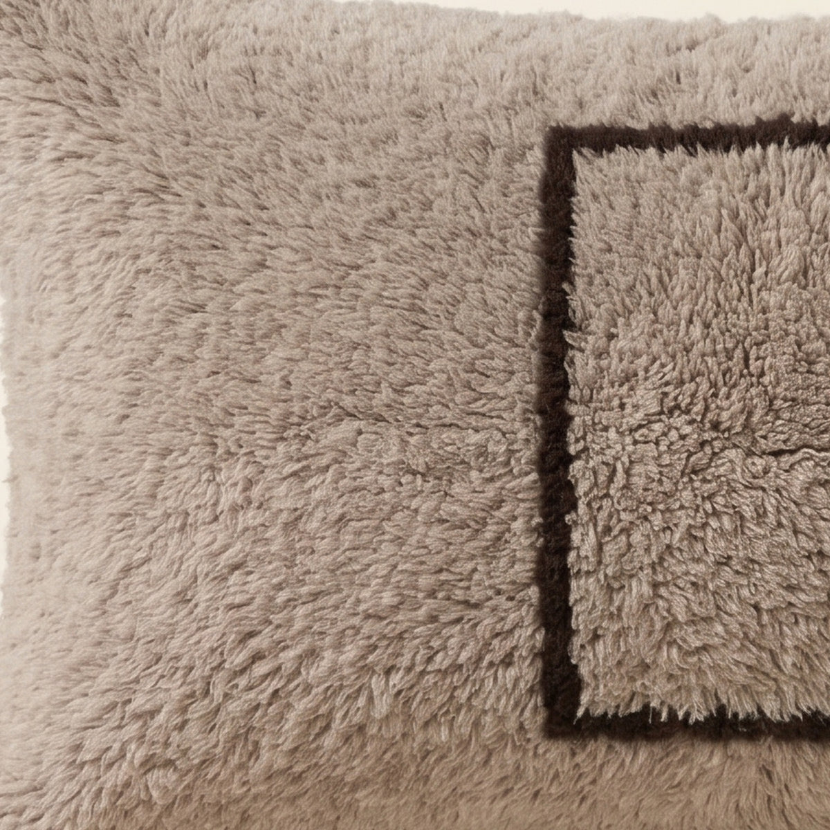 Side view of the Ilis Moroccan pillow showing its grey and black wool pile