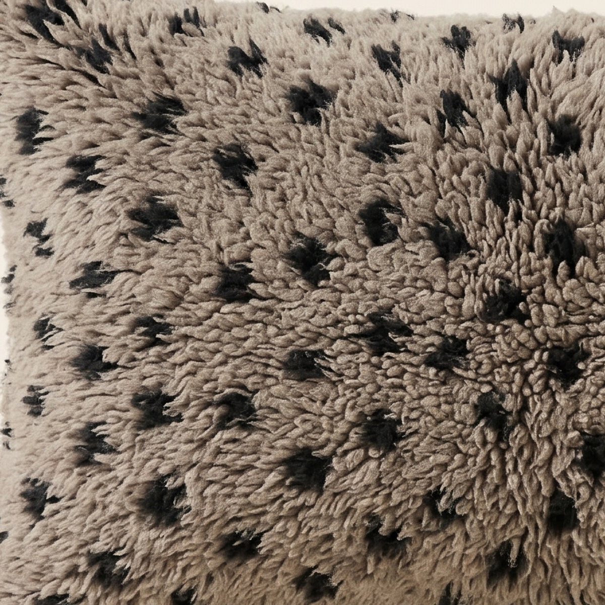 Side view of the Ilili Moroccan pillow showing its grey and black wool pile