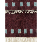 Hand-tied fringe and dense Atlas wool detail of the Idir burgundy rug.