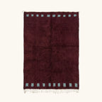 Full view of the Idir burgundy Beni Ourain rug with a rich border block motif and hand-tied fringe.