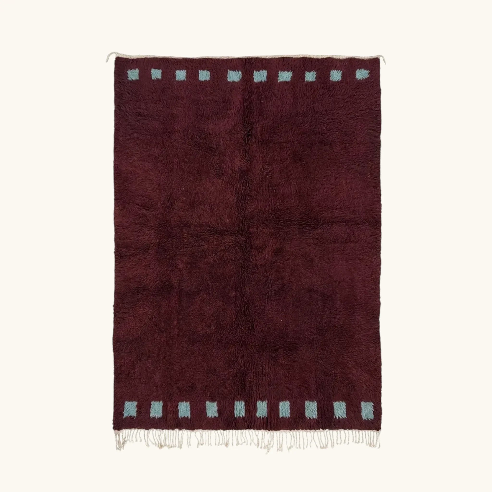 Full view of the Idir burgundy Beni Ourain rug with a rich border block motif and hand-tied fringe.