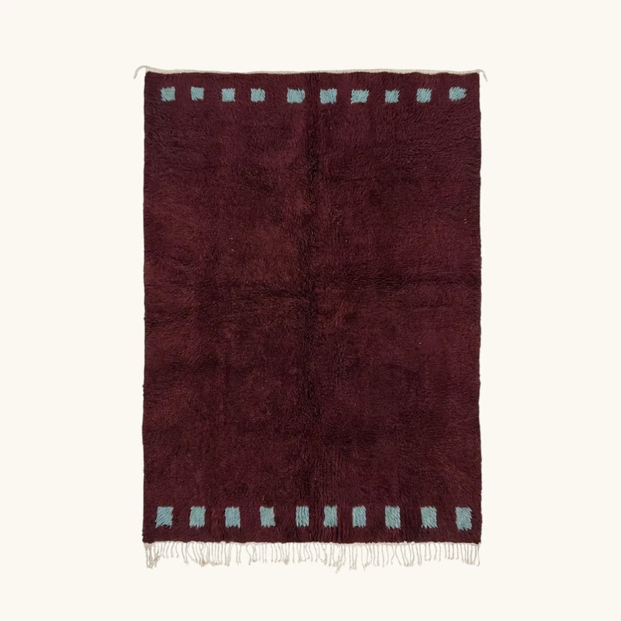 Full view of the Idir burgundy Beni Ourain rug with a rich border block motif and hand-tied fringe.