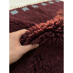 Soft burgundy and ivory wool texture detail of the Idir Moroccan rug.