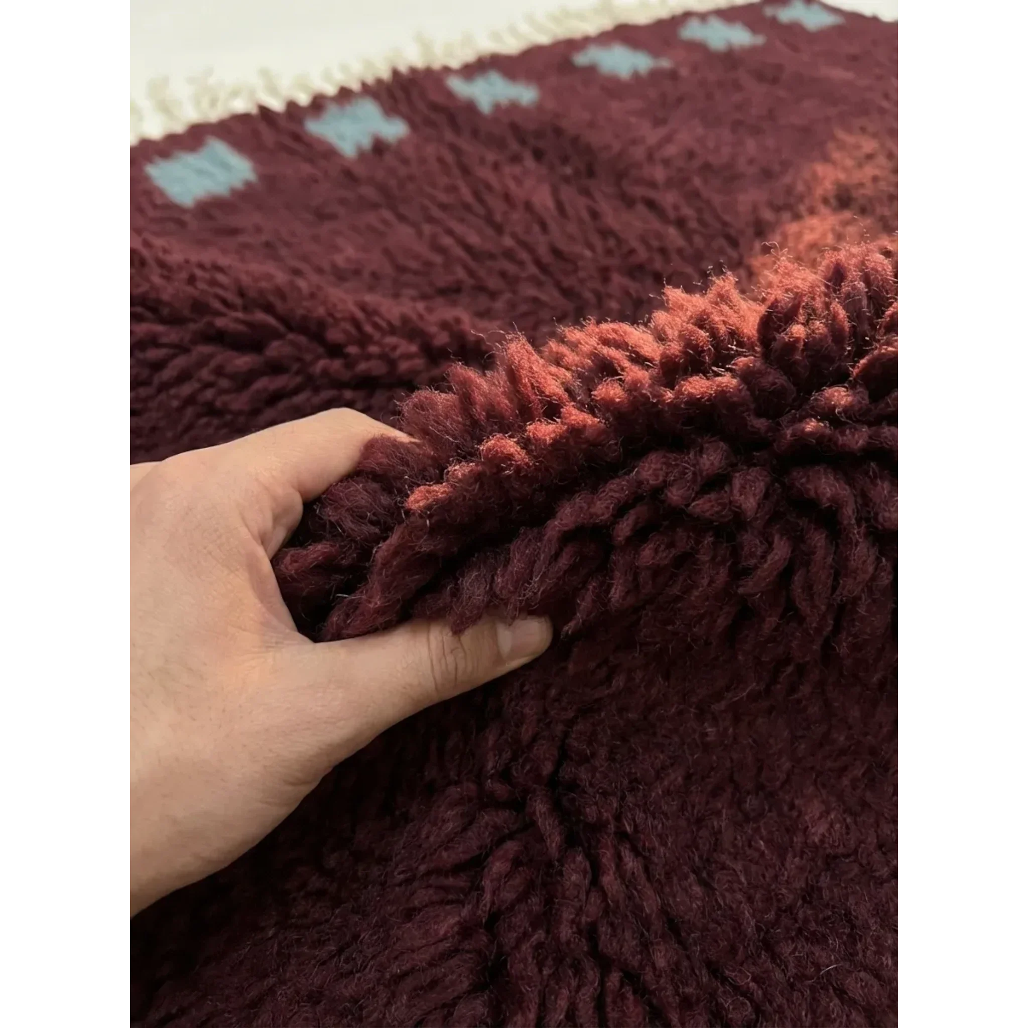 Soft burgundy and ivory wool texture detail of the Idir Moroccan rug.