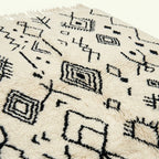Ivory Azilal rug Afelki with black tribal pattern, border detail