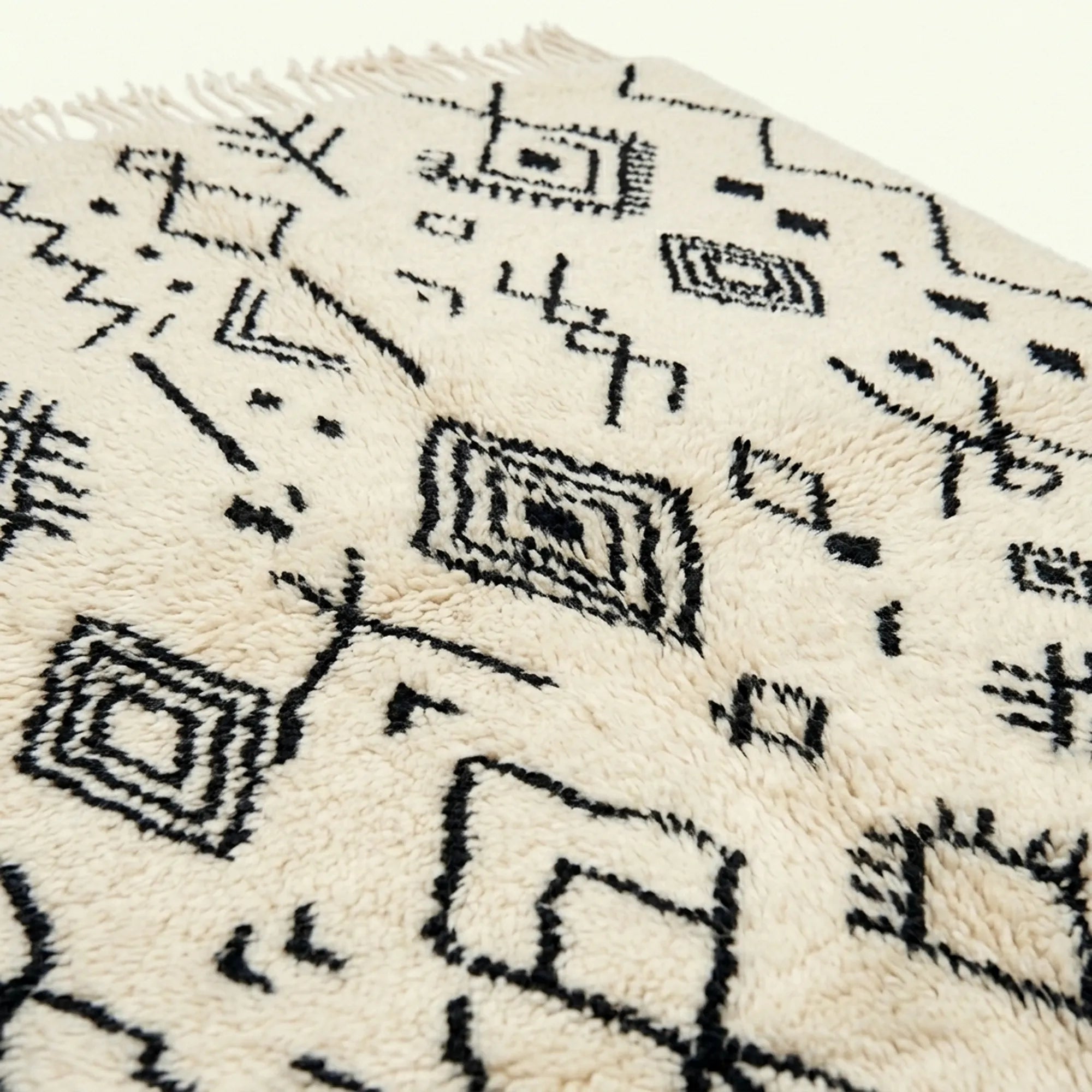 Ivory Azilal rug Afelki with black tribal pattern, border detail