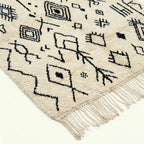 Ivory Azilal rug Afelki with black tribal pattern, fringe detail