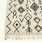 Ivory Azilal rug Afelki with black tribal pattern, craftsmanship detail