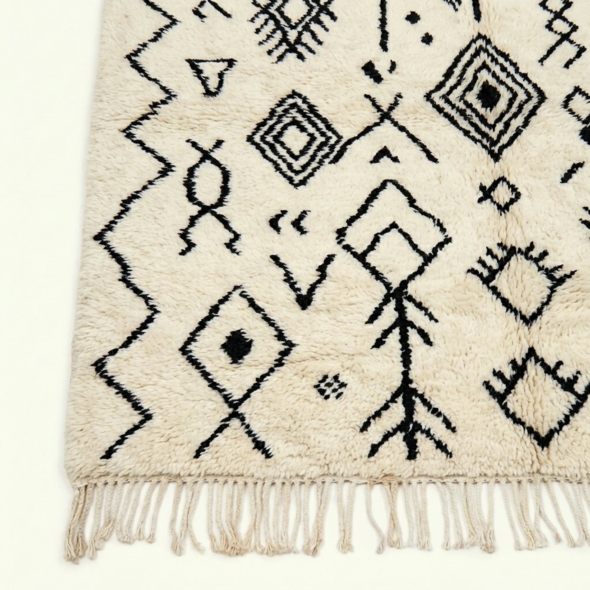 Ivory Azilal rug Afelki with black tribal pattern, craftsmanship detail