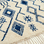 Ivory Azilal rug Imnayen with blue tribal diamonds, wool texture detail