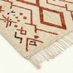Ivory Azilal rug Izri with rust linear diamond pattern, fringe detail