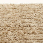 Close-up of ivory Beni Ourain pile texture showing horizontal stripe weave detail