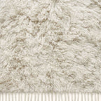 Edge detail of Ivory Beni Ourain rug showing natural wool fringe and textured pile
