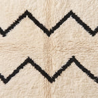 Overhead close-up of chevron motif showing contrast between black and ivory hand-knotted wool strands