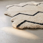 Edge view of Beni Ourain rug showing scalloped edge and fringe detail with chevron pattern