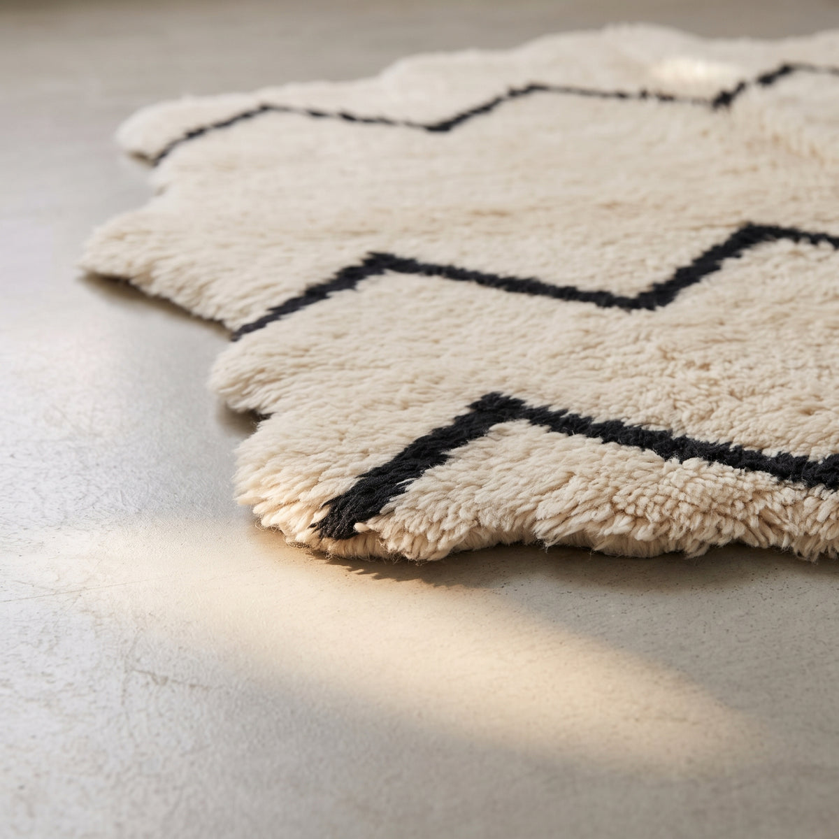 Edge view of Beni Ourain rug showing scalloped edge and fringe detail with chevron pattern