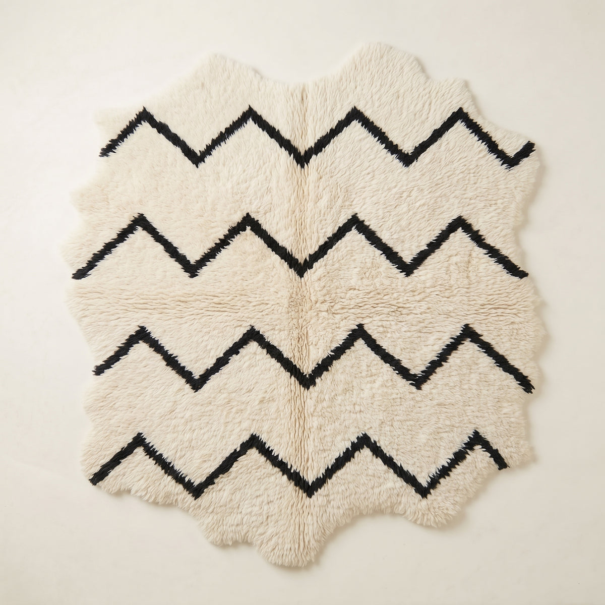 Ivory and black Beni Ourain rug with horizontal chevron stripe design, full view on plain background
