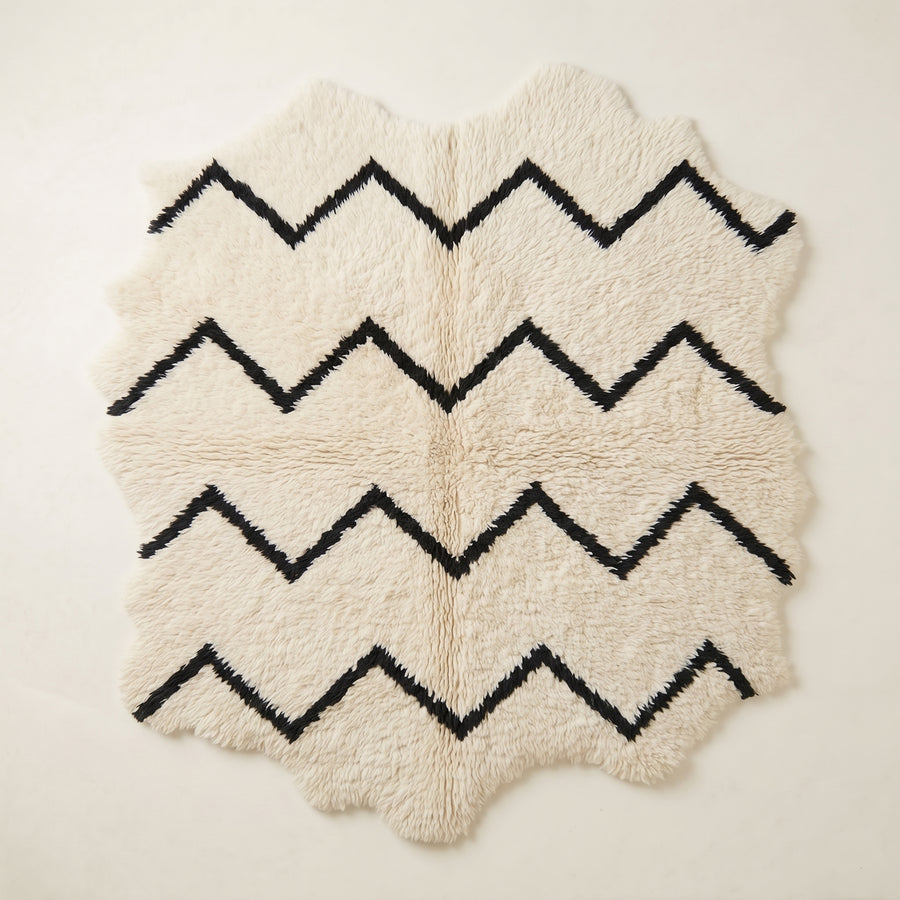 Ivory and black Beni Ourain rug with horizontal chevron stripe design, full view on plain background