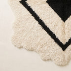 Corner and fringe detail showing irregular wavy edge and soft tasseled hem of Beni Ourain rug