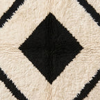 Close-up detail of inner black diamond and surrounding cream bands with hand-knotted wool pile