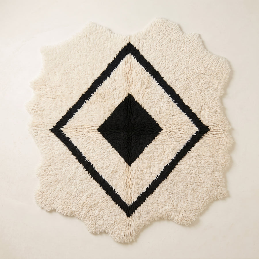 Ivory and black Beni Ourain rug with nested diamond lattice design and irregular scalloped edges, full flat view